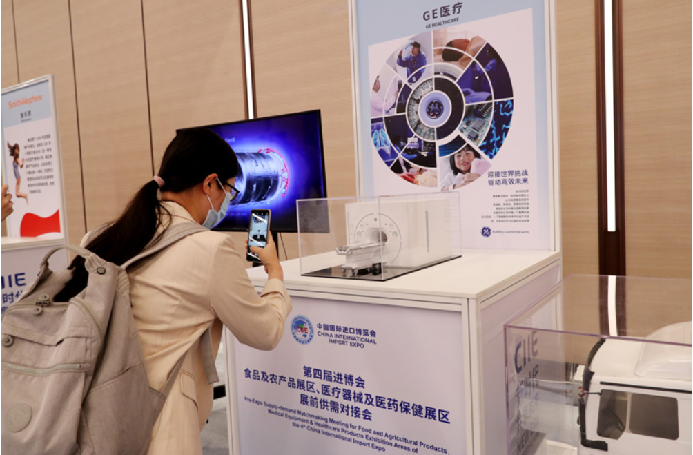 第四屆進(jìn)博會(huì )食品及農產(chǎn)品展區、醫療器械及醫藥保健展區展前供需對接會(huì )的參會(huì )嘉賓用手機拍攝參展企業(yè)的展品模型